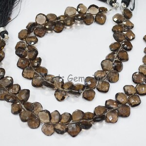 May include: A strand of brown smoky quartz faceted beads. The beads are strung on a clear elastic cord and are approximately 10mm in size.