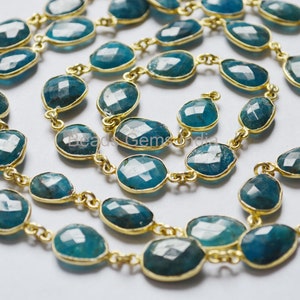 Könnte beinhalten: Eine Kette aus blaugrünen Edelsteinperlen mit goldenen Akzenten. Die Perlen sind oval geformt und haben eine facettierte Oberfläche. Die Kette ist etwa 45 cm lang.