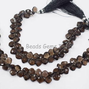 May include: Two strands of brown faceted gemstone beads with black tassels. The beads are strung on a silver wire.