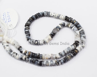 May include: A strand of white and gray opal beads with black speckles. The beads are round and have a slightly irregular shape. The strand is approximately 18 inches long.