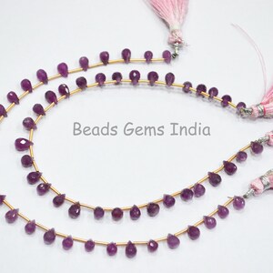 Op de afbeelding: Een streng paarse edelsteen kralen met gouden afstandhouders en roze kwastjes. Beads Gems India.