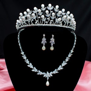 May include: A silver tiara with faux pearls and clear rhinestones, a matching necklace with a pear-shaped pendant, and a pair of earrings with pear-shaped drops.