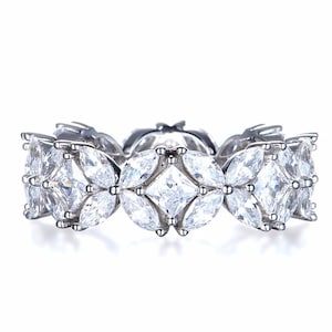 May include: A silver ring featuring a row of clear, marquise-shaped stones set in a pave setting.
