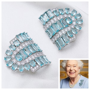 K&ouml;nnte beinhalten: Ein Paar Ohrringe aus Silber und blauem Aquamarin. Die Ohrringe bestehen aus einer Reihe von rechteckigen und ovalen Steinen, die in Silber gefasst sind.