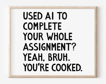 May include: A framed print with the text "USED AI TO COMPLETE YOUR WHOLE ASSIGNMENT? YEAH, BRUH. YOU'RE COOKED." in bold black letters on a white background. The frame is a light wood color.