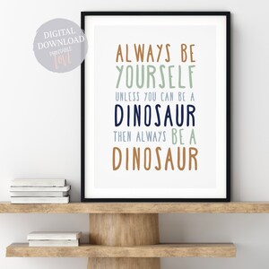 May include: A printable wall art print with the text "Always be yourself unless you can be a dinosaur then always be a dinosaur" in various colors on a white background.