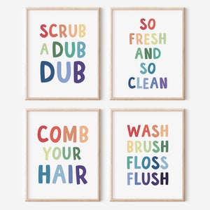 Może przedstawiać: Cztery kolorowe, oprawione wydruki z tekstem o tematyce łazienkowej. Wydruki przedstawiają frazy "Scrub a Dub Dub", "So Fresh and So Clean", "Comb Your Hair" i "Wash Brush Floss Flush".