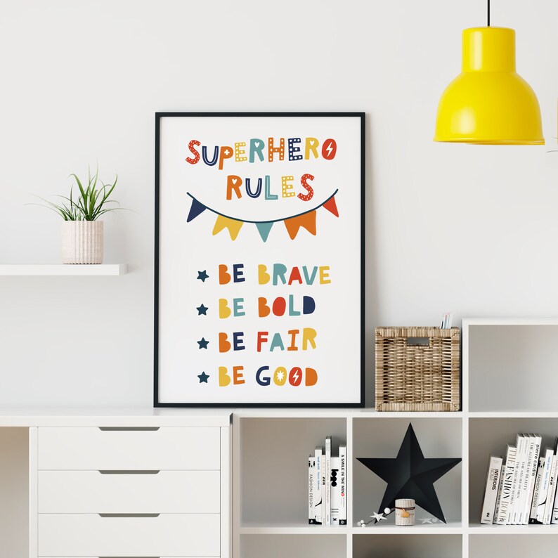 Op de afbeelding: Een kleurrijke printable poster met de tekst "SUPERHERO RULES" en een lijst met regels: "BE BRAVE", "BE BOLD", "BE FAIR", "BE GOOD".