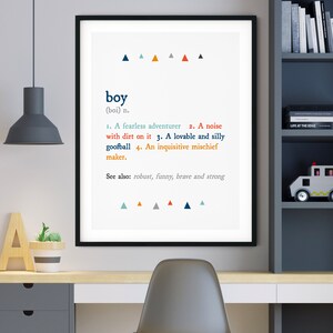 K&ouml;nnte beinhalten: Ein schwarzer gerahmter Druck mit wei&szlig;em Hintergrund und blauen, orangen und grauen Dreiecken. Der Druck zeigt das Wort "boy" in blauer Schrift und eine Definition des Wortes. Die Definition umfasst die W&ouml;rter "furchtloser Abenteurer", "L&auml;rm", "Tollpatsch" und "neugieriger Unfugmacher".