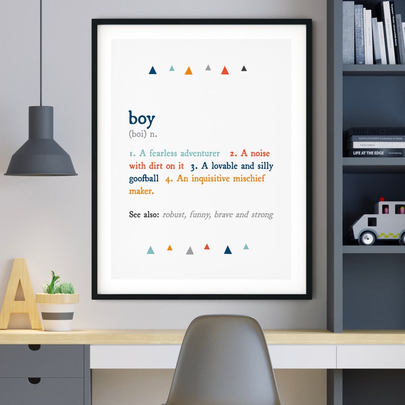 K&ouml;nnte beinhalten: Ein schwarzer gerahmter Druck mit wei&szlig;em Hintergrund und blauen, orangen und grauen Dreiecken. Der Druck zeigt das Wort "boy" in blauer Schrift und eine Definition des Wortes. Die Definition umfasst die W&ouml;rter "furchtloser Abenteurer", "L&auml;rm", "Tollpatsch" und "neugieriger Unfugmacher".
