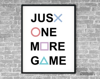May include: Black and white framed print with the text "JUST ONE MORE GAME" in bold letters. The text is decorated with a blue X, a pink circle, a purple square, and a blue triangle.