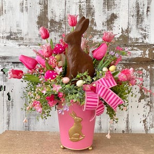 May include: A white ceramic mug with a black handle and the text "But First, Coffee" in a black, bold font. The mug is on a white surface.