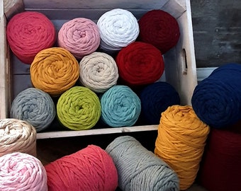May include: A variety of colors of cotton rope yarn in a wooden crate and on a wooden floor. The colors include white, red, green, blue, yellow, pink, and gray.