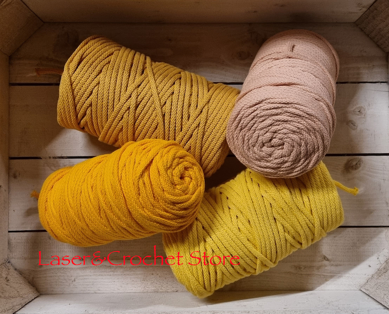 May include: Four spools of cotton rope in a wooden box. Two spools are a bright yellow colour and two spools are a light beige colour.