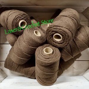 Puede incluir: Primer plano de una pila de cuerda de algodón marrón, con el texto "Laser & Crochet Store" visible en el fondo.