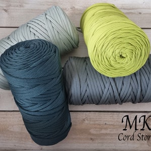 May include: Four spools of thick, colourful cord in green, grey, and blue. The spools are arranged on a wooden surface. The text "MK Cord Store" is visible in the bottom right corner of the image.