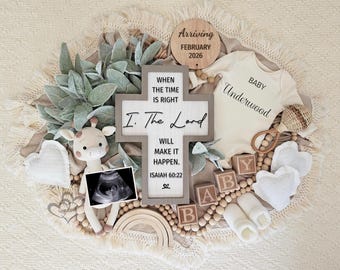 May include: A baby announcement featuring a cream-colored onesie with "BABY Underwood" printed on it, surrounded by wooden blocks spelling "BABY", a crochet giraffe, and a wooden cross with a Bible verse. A wooden sign says "Arriving February 2026".