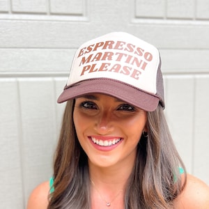 May include: A brown and tan trucker hat with the text "ESPRESSO MARTINI PLEASE" in brown lettering. The hat has a brown brim and a mesh back. The hat is a casual accessory.
