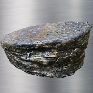 May include: A unique, handcrafted decorative display stand with a textured, layered design. The stand is primarily dark gray with gold accents, creating a rustic and elegant appearance. The stand's surface is approximately 12 inches in diameter.