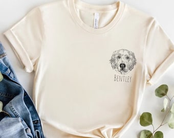 Puede incluir: Una camiseta de color crema con una ilustración en blanco y negro de la cabeza de un perro golden retriever y el nombre "Bentley" impreso en la parte delantera.