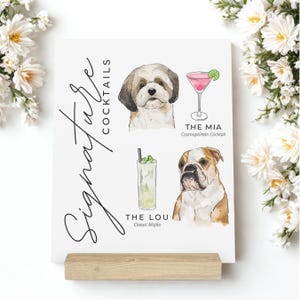 Peut inclure: Une affiche imprimable blanche avec le texte "Signature Cocktails" en haut. L'affiche présente deux illustrations à l'aquarelle de chiens, l'une avec un cocktail Cosmopolitan et l'autre avec un Mojito. Le texte sous chaque chien indique "The Mia Cosmopolitan Cocktail" et "The Lou Classic Mojito".