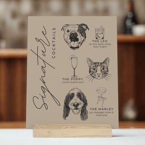 May include: A tan cocktail menu with black illustrations of a dog, cat, and cocktails. The menu includes the text "Signature Cocktails" and drink names like "The Leo" and "The Marley". The menu is held in a wooden stand.