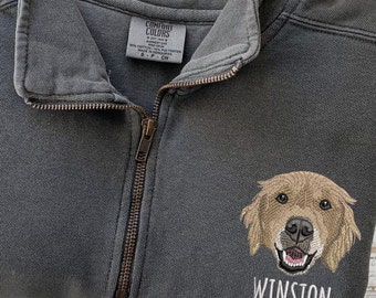 May include: A dark gray fleece pullover with a zipper. The pullover has an embroidered image of a golden retriever dog with the name "Winston" underneath.