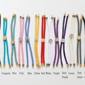 May include: A collection of colorful corded jewelry findings in various colors, including black, turquoise, mint, pink, blue, yellow, red, white, purple, dark purple, cream, sage green, and dark green. Each has a metal clasp and a decorative center piece. The text at the bottom reads: Black Turquoise Mint Pink Blue Yellow Red White Purple Dark Purple Cream Sage Green Dark Green.