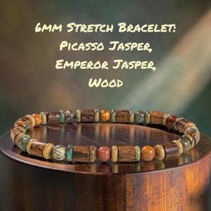 May include: A 6mm stretch bracelet featuring a repeating pattern of round Picasso jasper beads, round Emperor jasper beads, and cylindrical wood beads. The text 6mm Stretch Bracelet: Picasso Jasper, Emperor Jasper, Wood is displayed above.