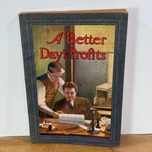 May include: A vintage hardcover book titled A Better Day's Profits with a dark gray border. The cover illustration depicts two men in suits working at a desk with papers, a small inkwell, and a vintage telephone in a dimly lit office setting.