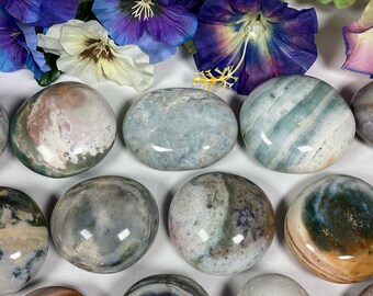 May include: A collection of 10 smooth, polished, colorful, and patterned agate stones. The stones are various shades of green, blue, brown, white, and pink.