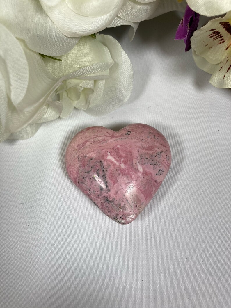 May include: A pink and white heart-shaped stone with a marbled pattern.