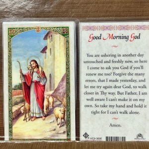 May include: A religious card with a painting of a figure in red and white robes holding a staff, surrounded by sheep. The card on the right has the text "Good Morning God" and a prayer.
