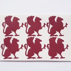 May include: Six burgundy-colored griffin silhouettes on a white background. The griffins are facing right and have their wings spread out.