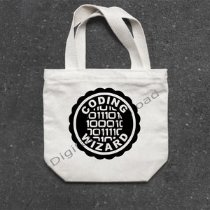 Puede incluir: Bolsa de tela blanca con asas negras y un dise&ntilde;o circular negro que dice "Coding Wizard" con c&oacute;digo binario dentro del c&iacute;rculo.