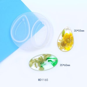 May include: Two clear silicone moulds for making resin earrings, one oval mould and one teardrop mould.  Two resin pendants with dried flowers, one oval and one teardrop shaped.  The oval pendant is 35 x 60 mm and the teardrop pendant is 35 x 55 mm.  The moulds are labelled MD1165.