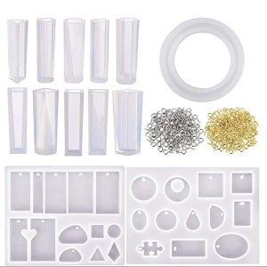 May include: A set of clear silicone molds for making resin jewelry. The set includes various shapes, including circles, squares, rectangles, ovals, and a puzzle piece. There are also several molds for making different sized and shaped pendants. The set also includes a large round mold, and two bags of jump rings, one silver and one gold.