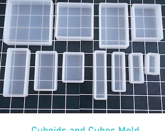 May include: A set of 10 clear silicone molds for making cuboids and cubes. The molds are arranged in rows on a black grid background.