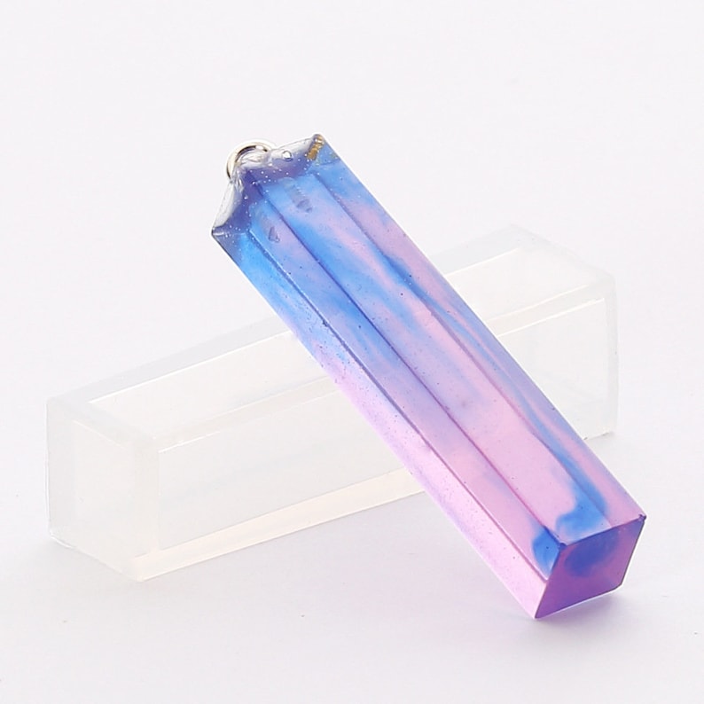 May include: A long, rectangular pendant made of clear resin with blue and pink swirls. The pendant has a silver loop at the top for hanging.