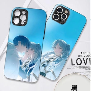 Puede incluir: Dos fundas para teléfono con un fondo de cielo azul. Las fundas presentan una ilustración de estilo anime de una pareja abrazándose. El texto en la funda dice "Around the Clock Love".