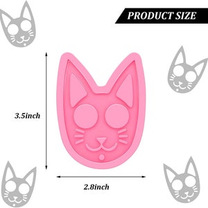 Op de afbeelding: Een roze katvormige mal, 8,9 cm hoog en 7,1 cm breed, met grote ronde ogen en een kleine neus. De woorden "PRODUCT SIZE" staan in een zwarte banner bovenaan. Verschillende grijze kattengezichtomtrekken omringen de hoofdvorm.