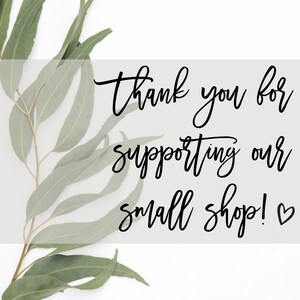 May include: Thank you for supporting our small shop! A handwritten message with a heart symbol on a white background with green eucalyptus leaves.