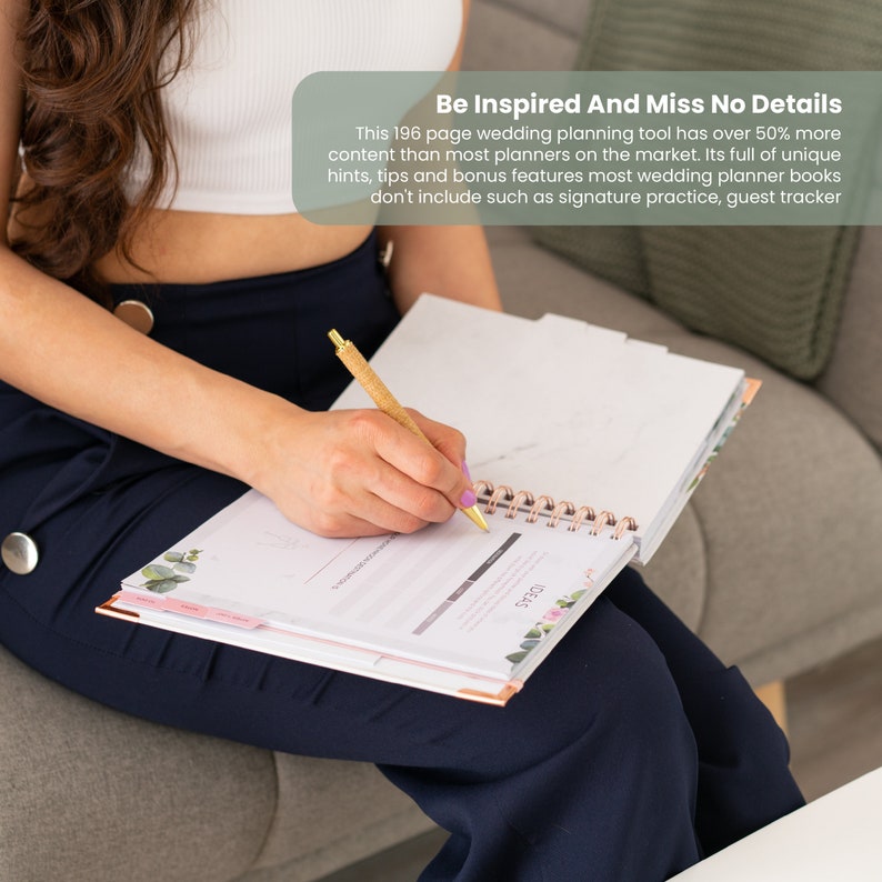 May include: A woman is writing in a pink and white wedding planner with a gold pen. The planner has a floral design and the text "Be Inspired And Miss No Details" on the cover. The planner has 196 pages and is full of unique hints, tips, and bonus features.