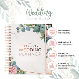 May include: A white and rose gold wedding planner with a marble and floral design. The cover says "The Ultimate Wedding Planner".