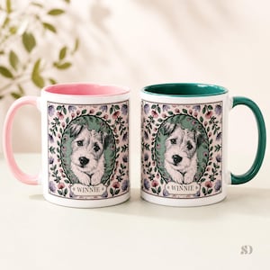 May include: Two white ceramic mugs with a dog portrait. One mug has a pink handle and interior, the other has a green handle and interior. Each mug features a floral wreath design around the dog portrait, with the name "Winnie" below.