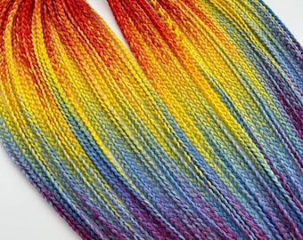 May include: A bundle of ombre braided hair extensions in shades of red, orange, yellow, blue, and purple.