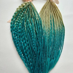 Puede incluir: Dos juegos de rastas sintéticas ombré. Las rastas son de color rubio claro en la parte superior y se desvanecen a un color verde azulado en la parte inferior.