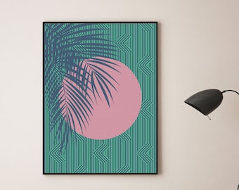 May include: A framed print with a pink circle and a blue palm leaf design on a green and white geometric background. The print is hanging on a light pink wall above two teal green armchairs.
