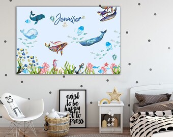 May include: A light blue canvas print with a watercolor illustration of a sea life scene. The print features whales, jellyfish, fish, and seahorses. The name "Jennifer" is written in a decorative font at the top of the print.