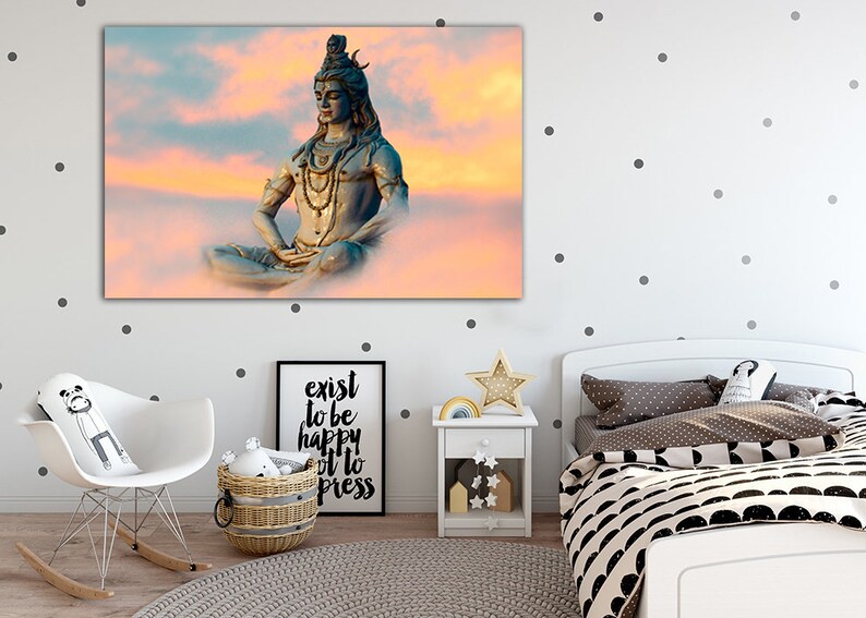 May include: A blue statue of Shiva meditating in a lotus position against a pink and orange cloudy sky.